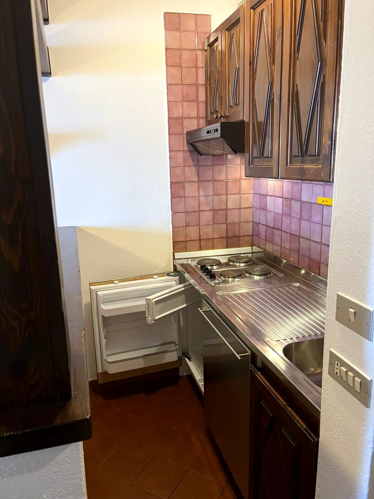 Angolo cottura con 4 piastre elettriche, lavello, cappa e frigorifero sottopiano